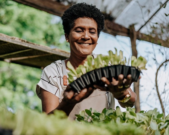 Woman holding plants smiling