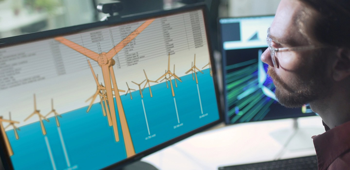 Close-up of an environmental scientist looking at wind turbine renderings on his computer screen.