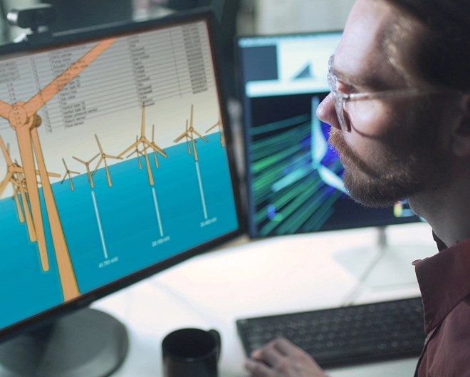 Close-up of an environmental scientist looking at wind turbine renderings on his computer screen.