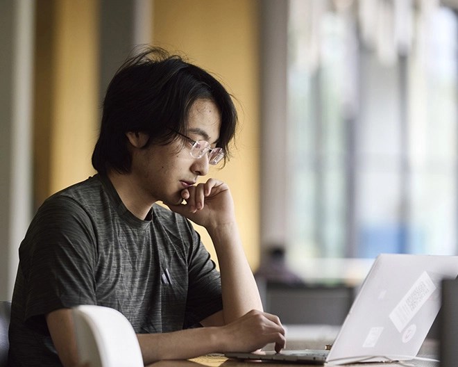 Online student works through his students on a laptop.