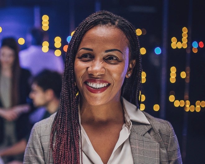 woman smiling with screens behind her
