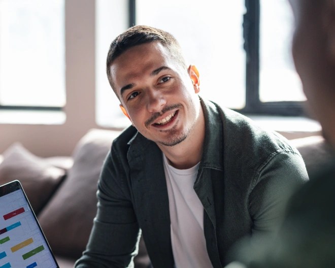 man sat down smiling at a colleague
