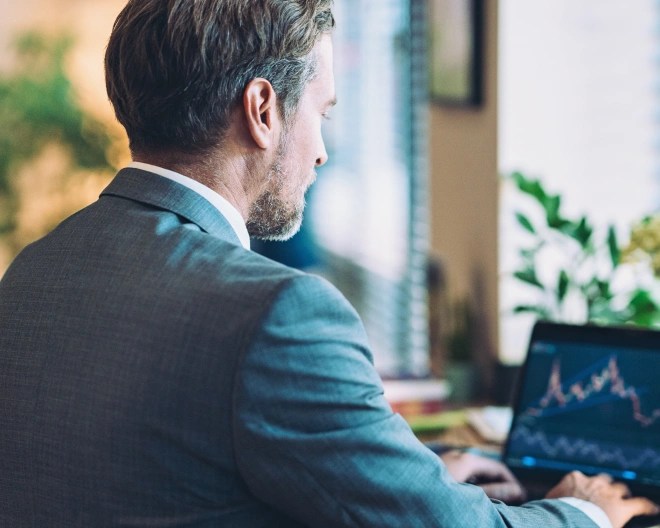 businessman sitting in an office working on his laptop