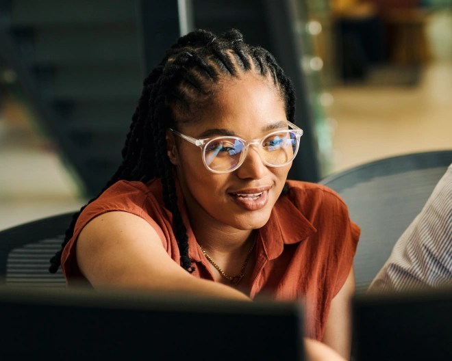 woman sat at a computer screen pointing to it
