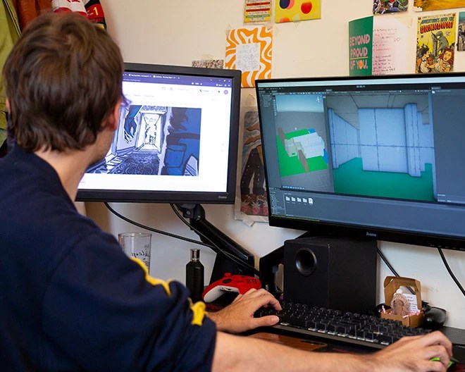 Student with two monitors and keyboard