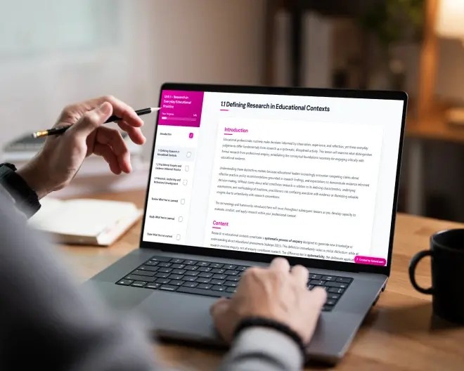 Close-up of a person’s hands holding a pencil and typing on a laptop on a table, with a module developed using Course Studio displayed on the screen.