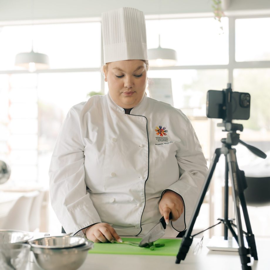Chef cooking with a tripod and camera filming them
