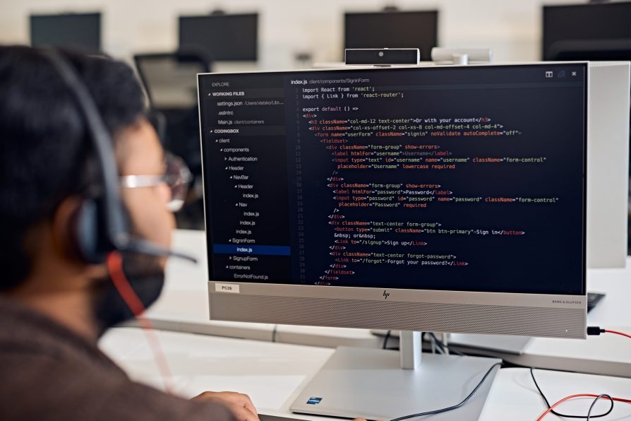Man working at a laptop reviewing code