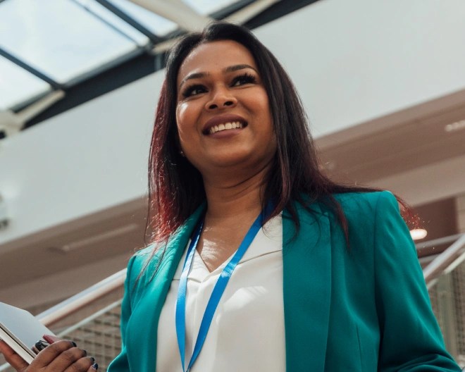 woman stood smiling with a lanyard on
