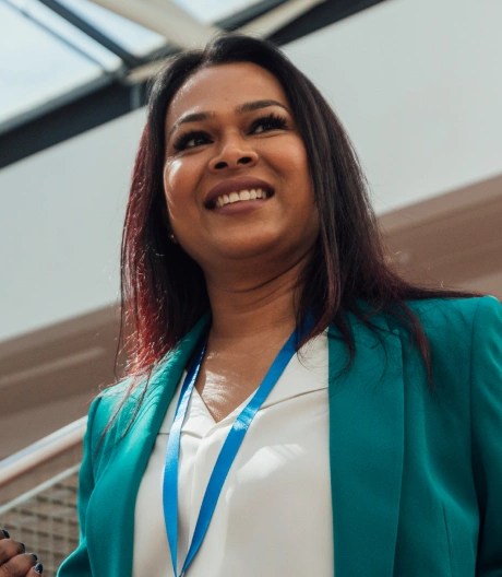 woman stood smiling with a lanyard on