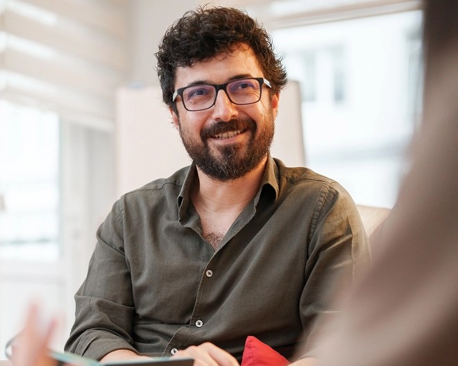 Man with glasses and beard having a conversation